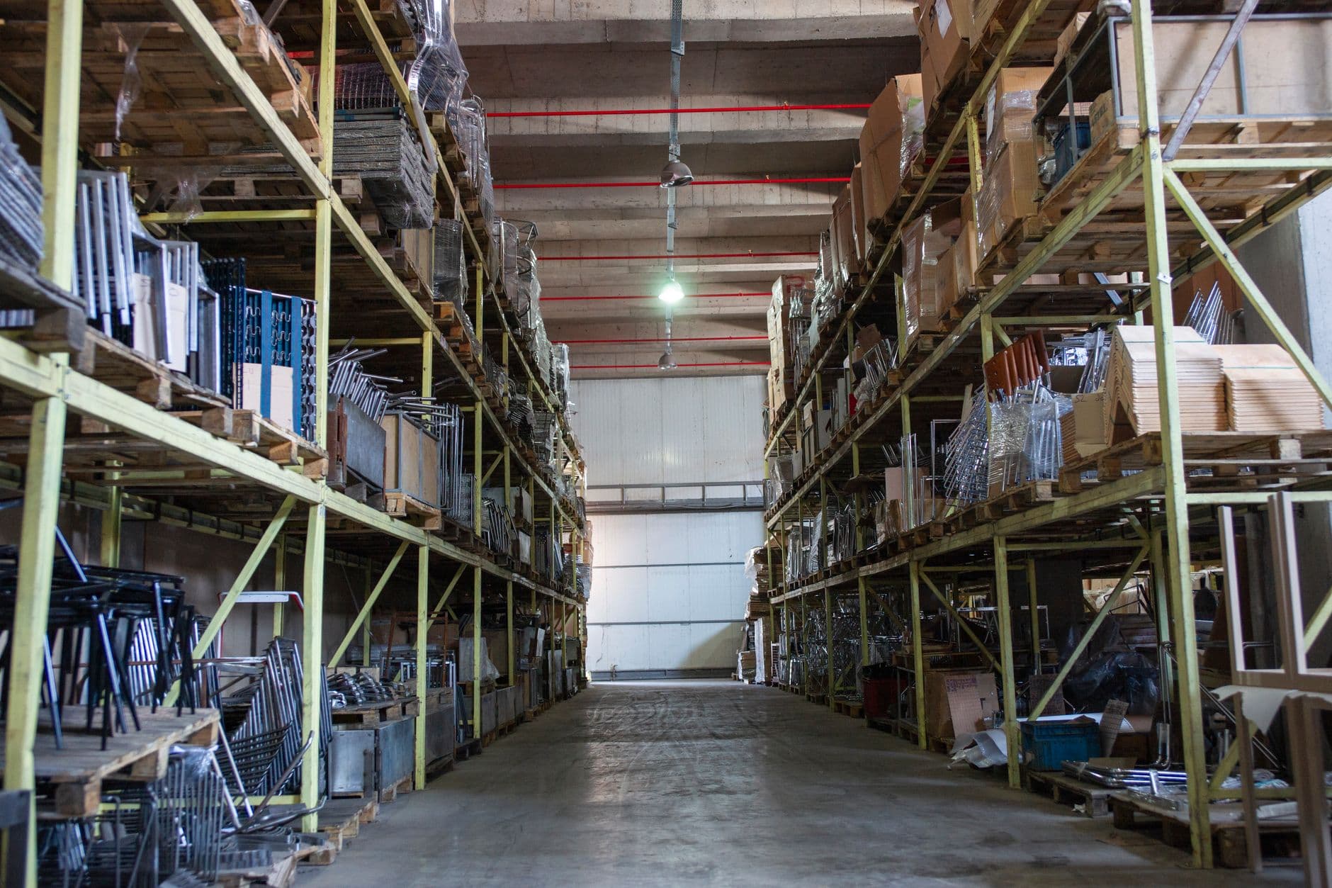 A wide aisle of industrial shelving in a distribution warehouse