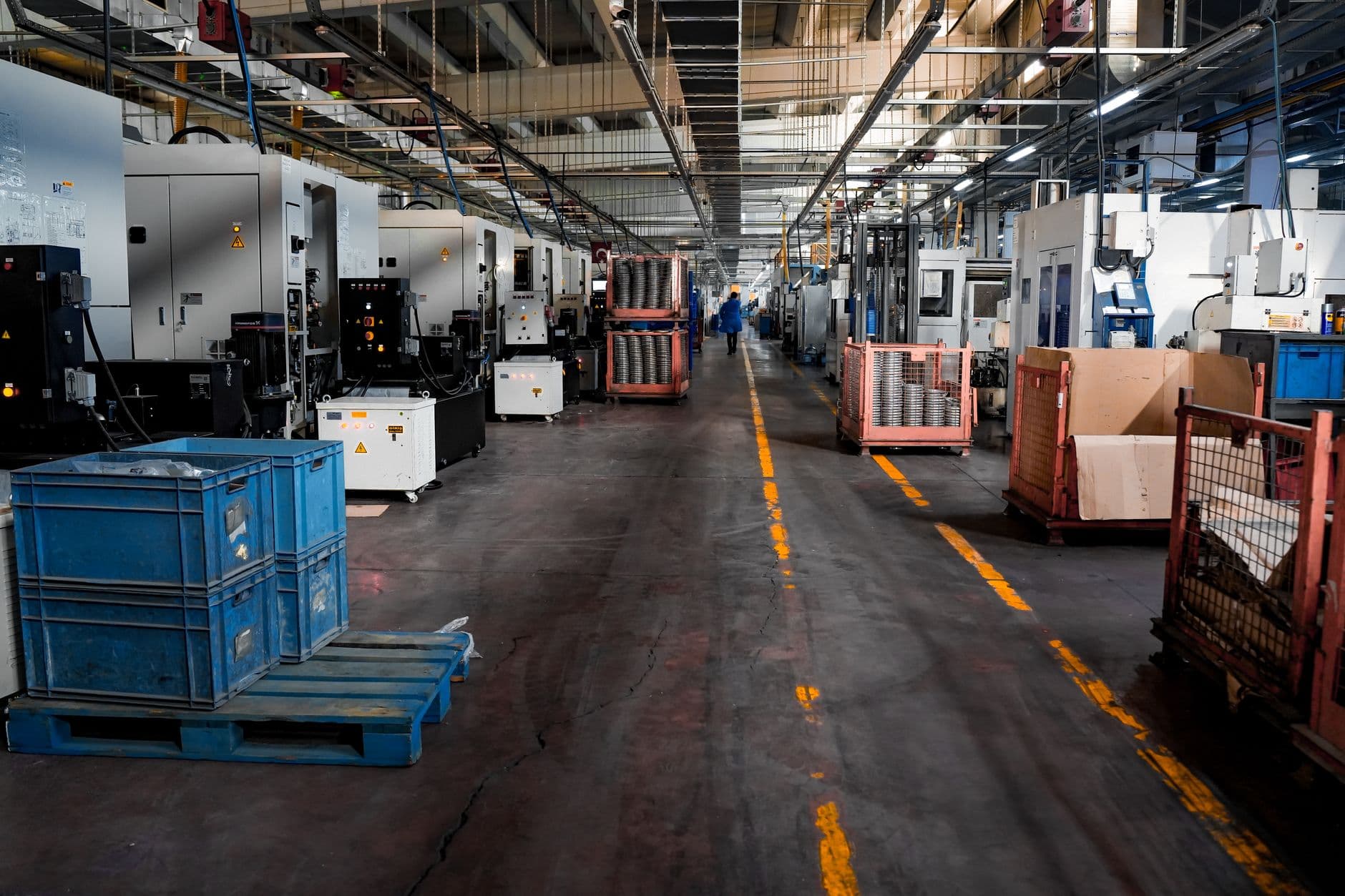 A machine shop floor lined with CNC machines and part trolleys